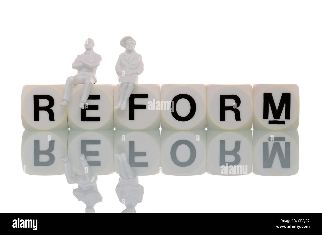 Two pensioner figurines sitting on the word reform, symbolic image for pension reform Stock Photo