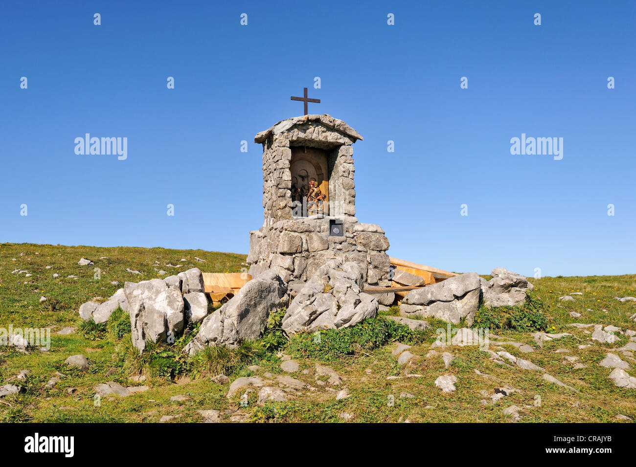 Wayside cross with a small altar and statues of saints on the high