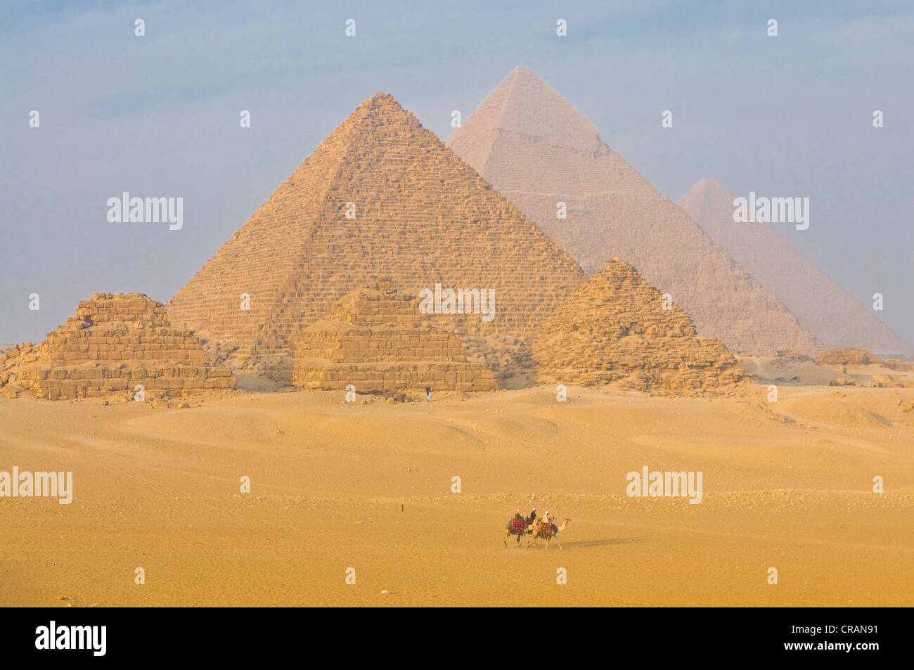 Riders on camels in front of the Pyramids of Giza, UNESCO World Heritage Site, Egypt, Africa Stock Photo
