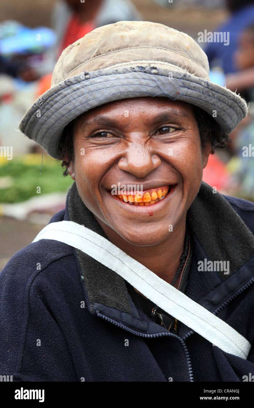 Woman with red teeth from chewing the betel nut at the market of Goroka, Papua New Guinea Stock Photo