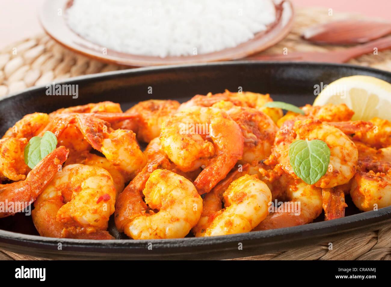Tandoori prawns on a cast iron sizzle platter, served with basmati rice. Stock Photo