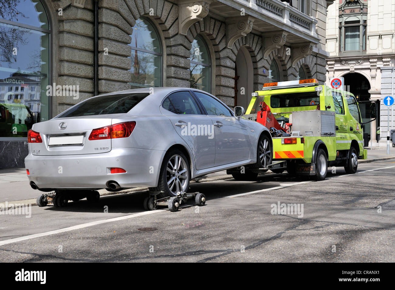A car is being towed away from a noparking zone in the historic Stock