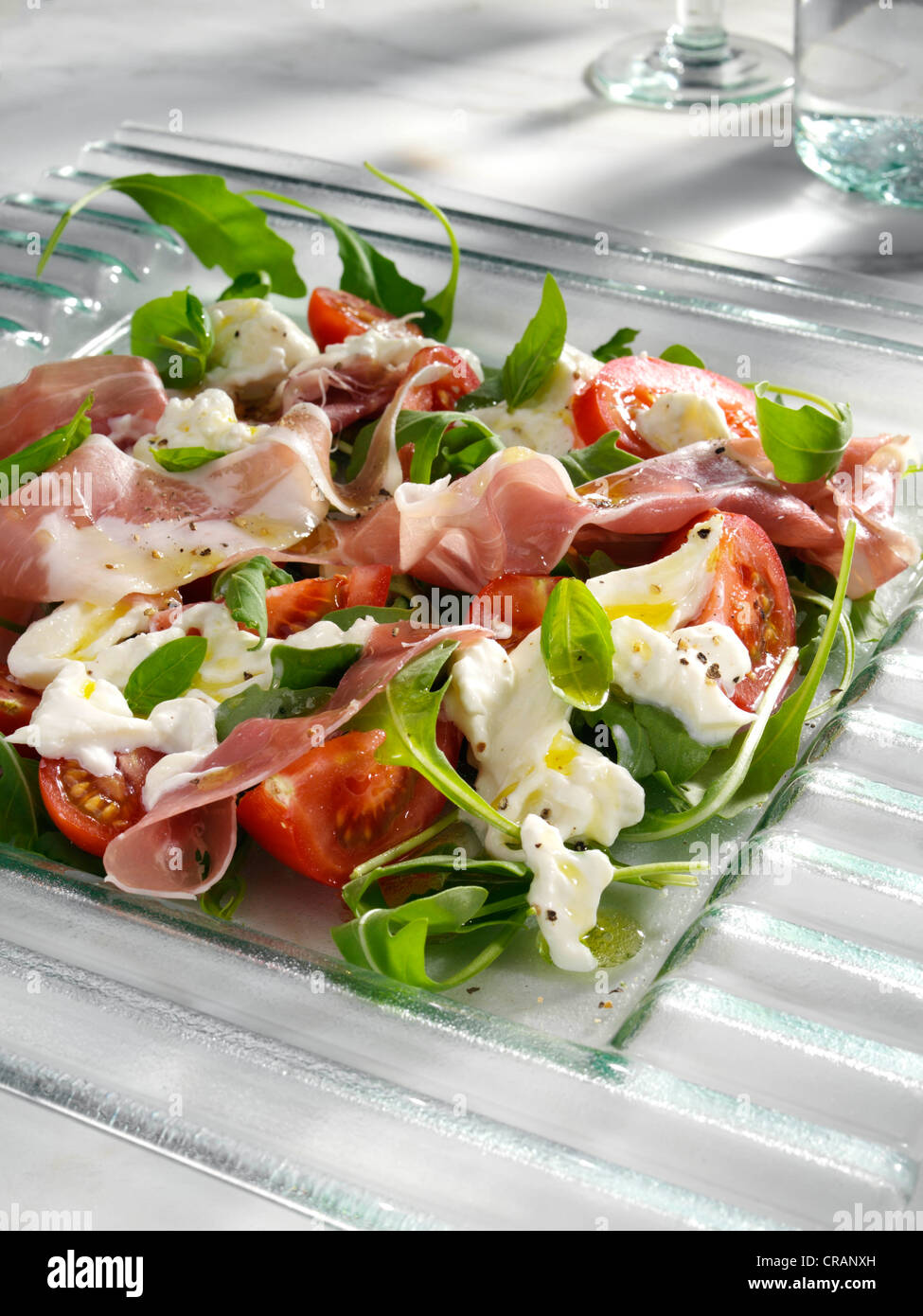 Burrata prosciutto ham and tomato salad Stock Photo Alamy