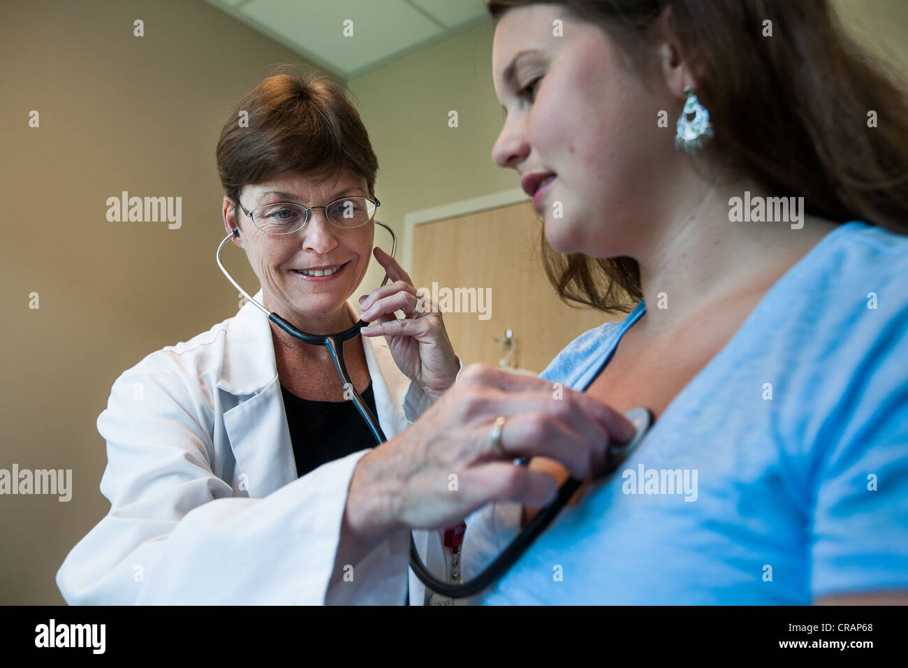 Doctor listens to patient's heart Stock Photo Alamy