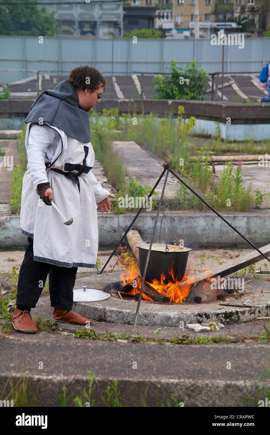 Kaliningrad, Russia - june 17, 2012, the man in a suit of the Teutonic knight cooks food on knightly tournament 'Royal mountain' Stock Photo