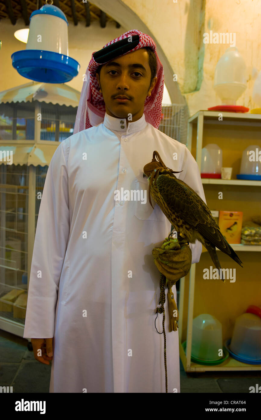 Young man with trained hawk in the bazaar Souq Waqif, Doha, Qatar, Arabian Peninsula, Middle East Stock Photo