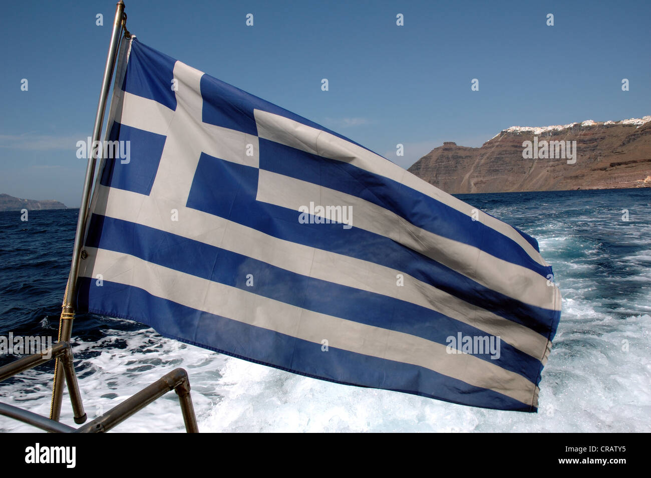 The Greek Flag Flies From The Stern Of A Boat Off Santorini Greece 