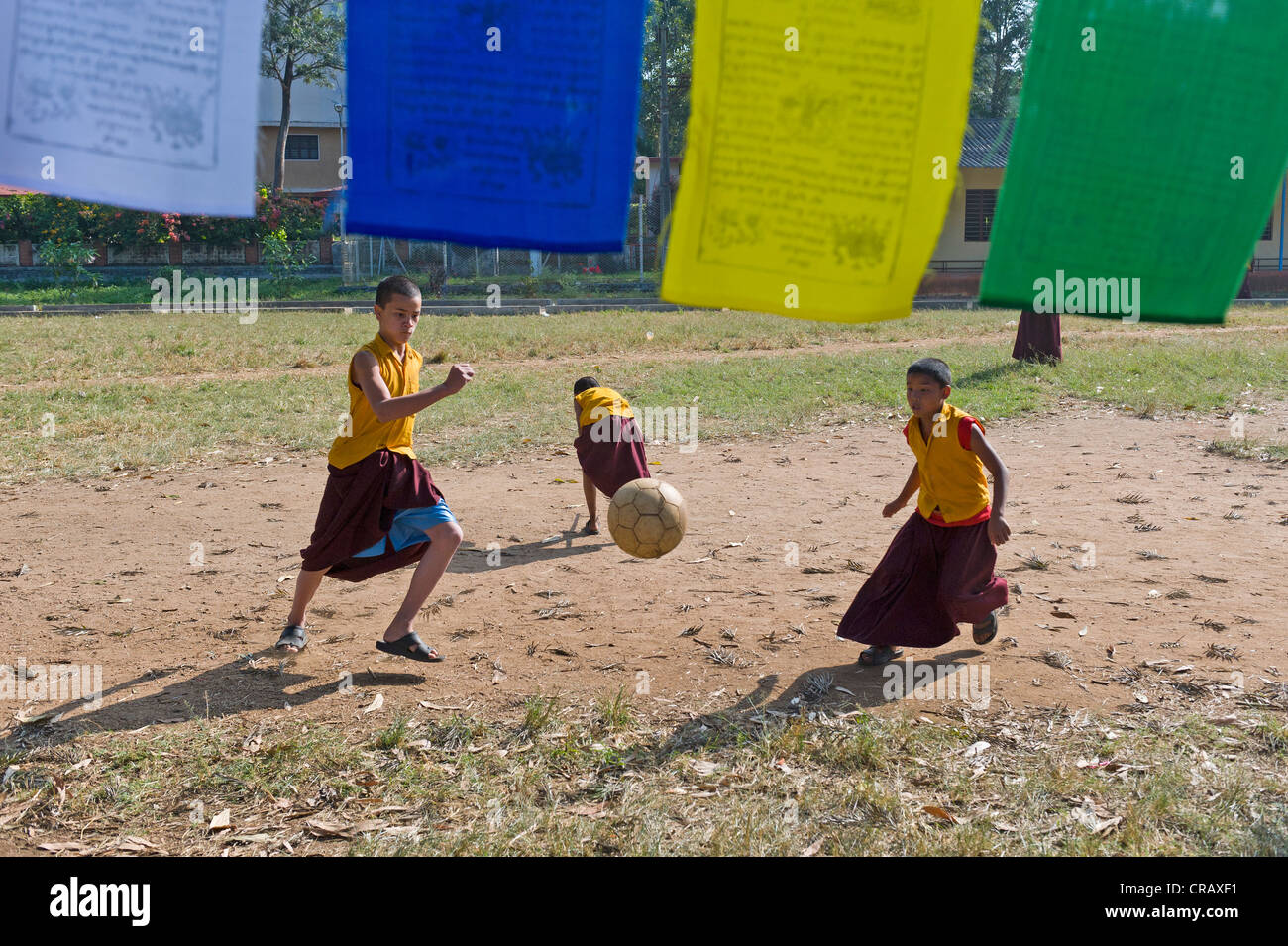 Young monks playing football, Tibetan refugee settlement in Bylakuppe, Mysore District, Karnataka, South India, India, Asia Stock Photo