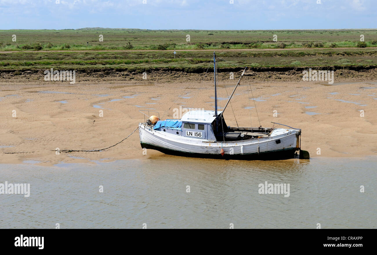 Small fishing boat moored up on a sand bank at low tide. Stock Photo