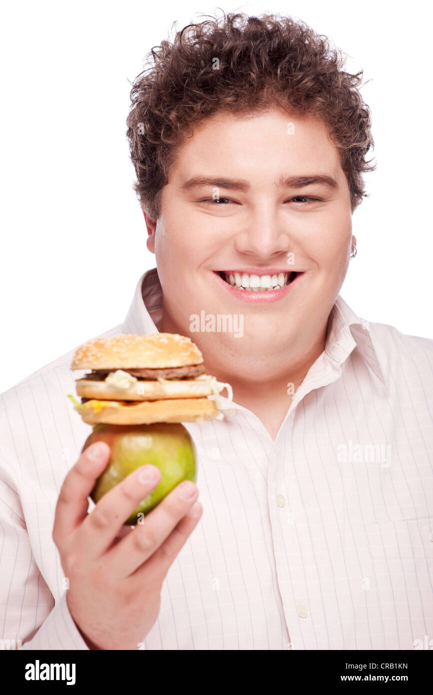 Young chubby man holding apple and hamburger, isolated on white Stock Photo