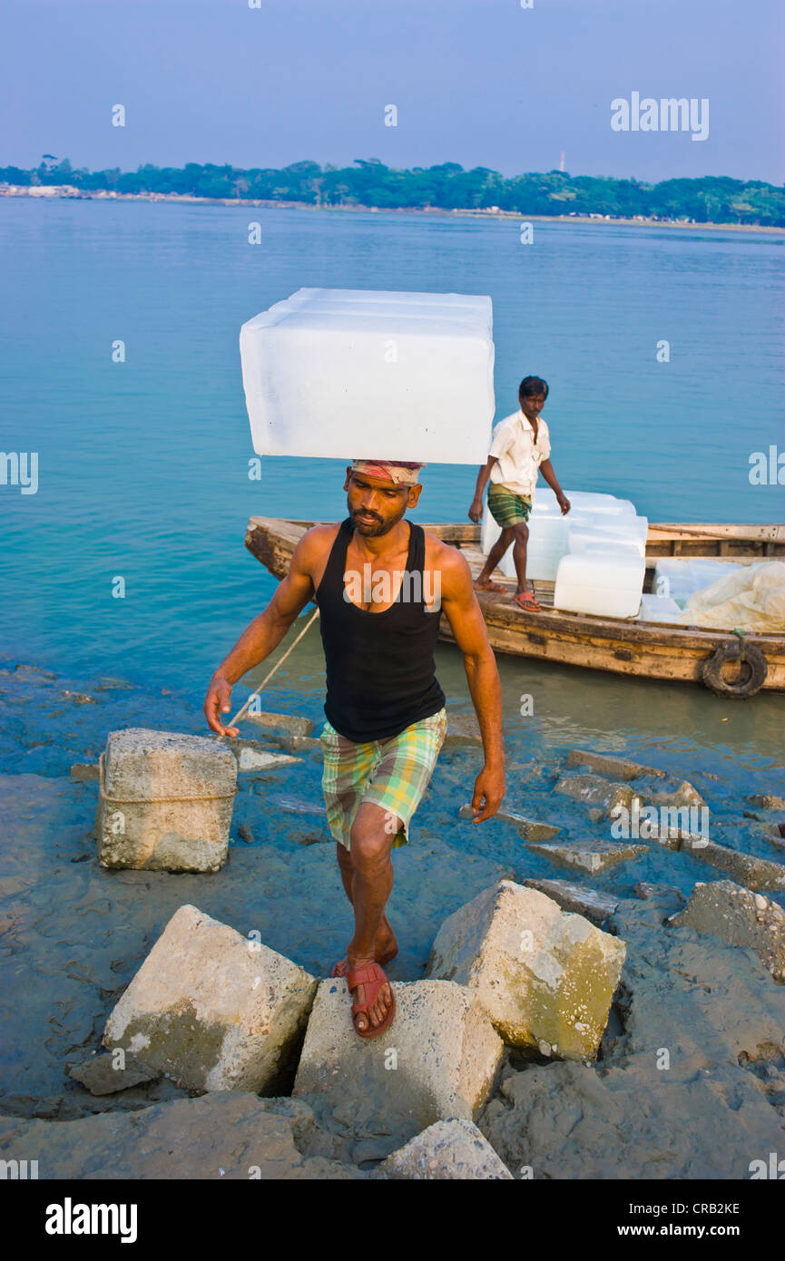 Man carrying a large block of ice on his head, Barisal, Bangladesh, Asia Stock Photo