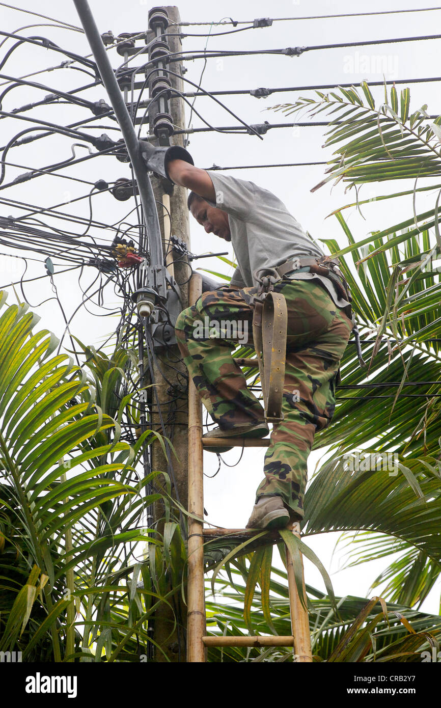 An electrician working on live power cables, Phuket Thailand Stock