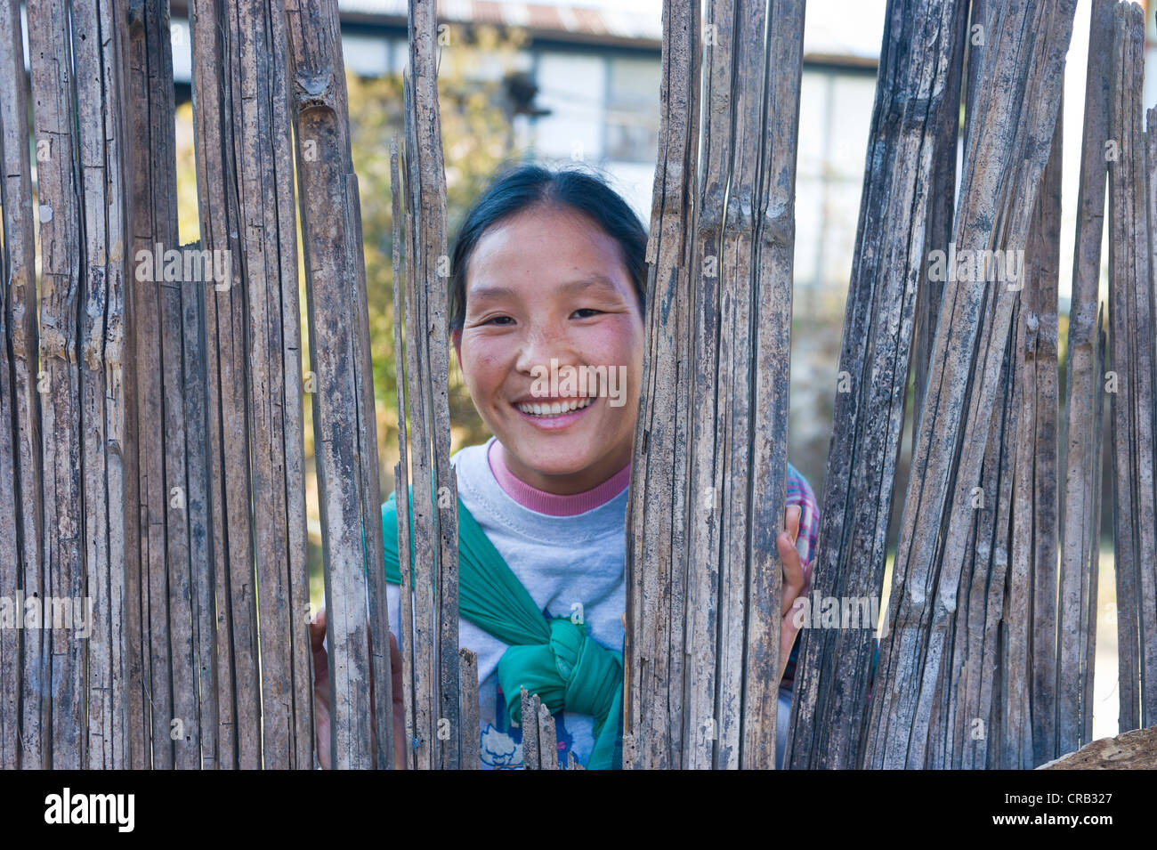 Tribal woman looks through a hole in a fence, Arunachal Pradesh, North East India, India, Asia Stock Photo