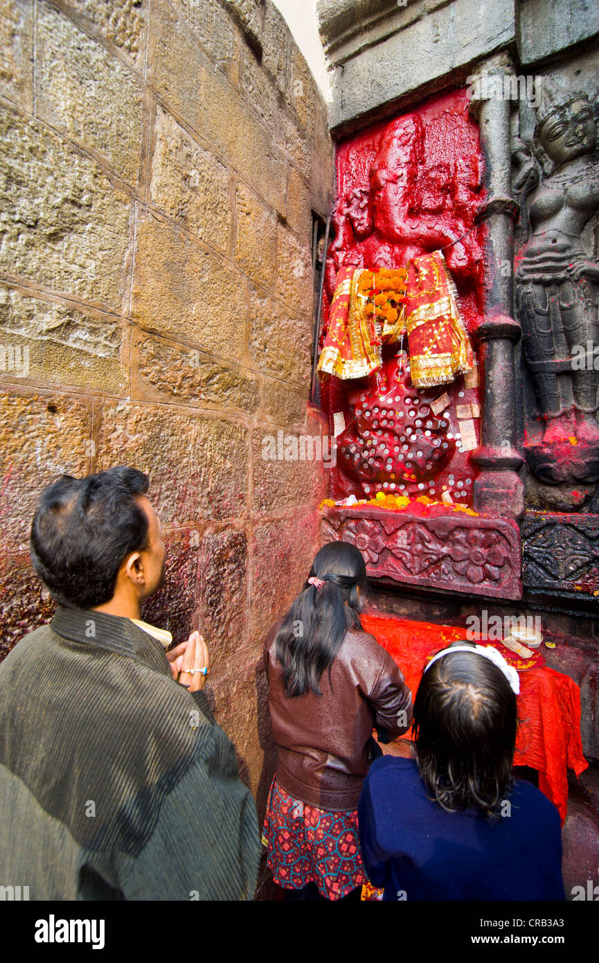 Pilgrims in front of a red-coloured stone statue in Kamakhya Temple, a Hindu temple, Guwahati, Assam, North East India, India Stock Photo