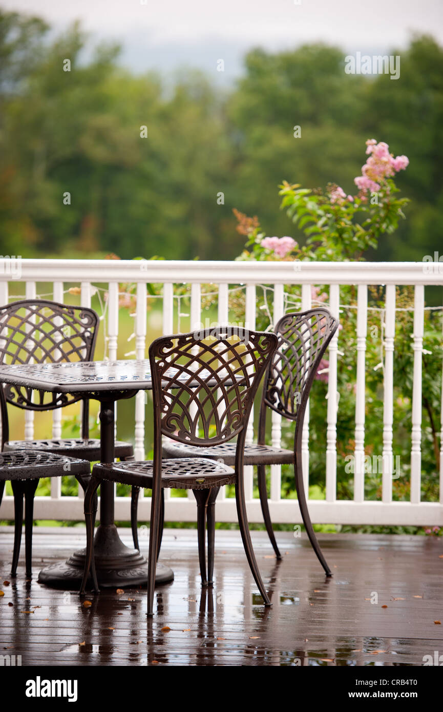 Set of outdoor metal furniture sitting on a deck overlooking a vineyard