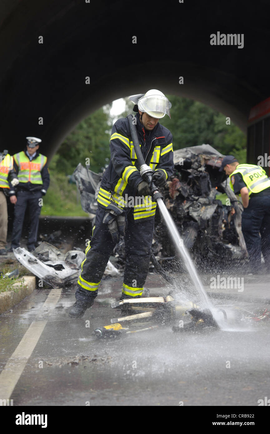 Firefighter cleaning hydraulic rescue equipment with a water jet after