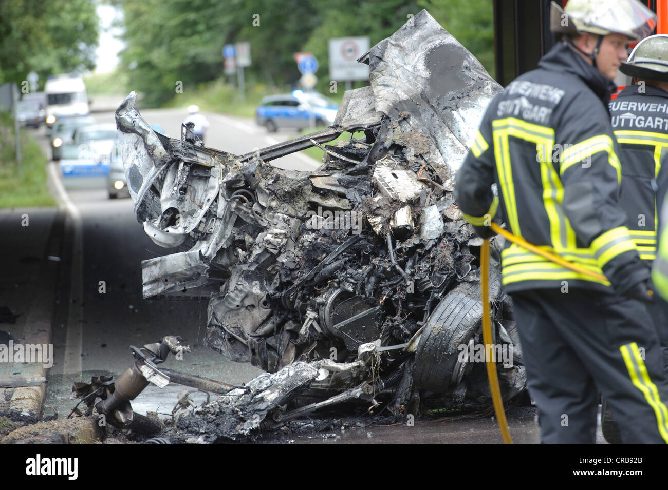 Firefighters attending the wreckage of an Audi car which was destroyed and burned out beyond recognition, Sindelfingen Stock Photo