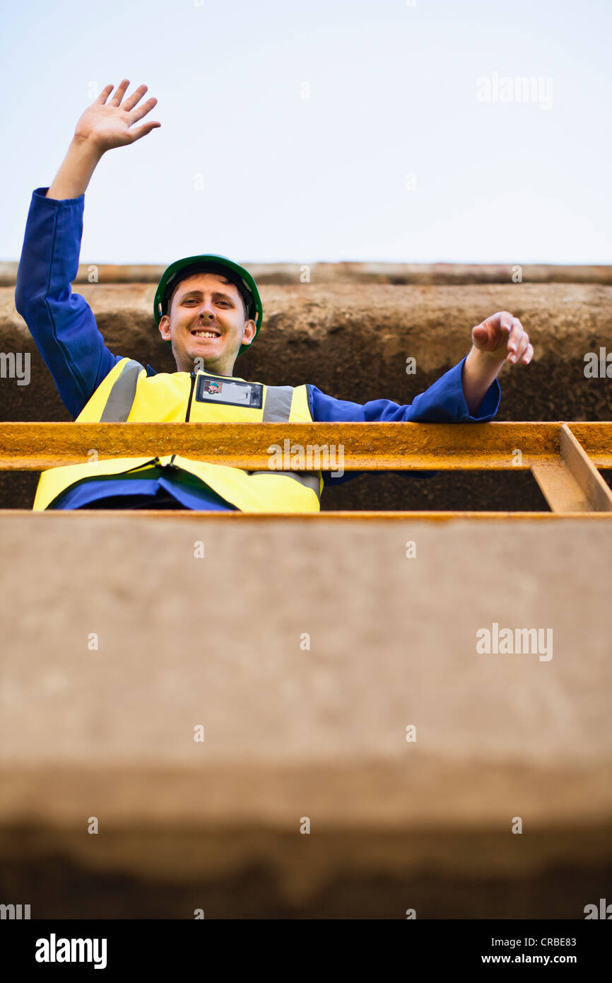 Worker waving from balcony Stock Photo