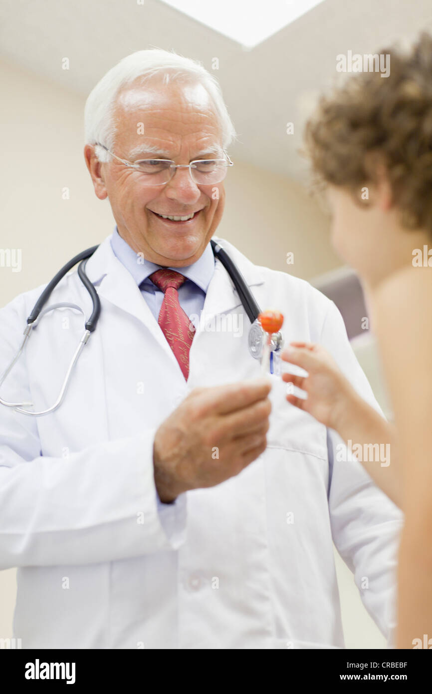 Doctor giving boy lollipop in office Stock Photo Alamy