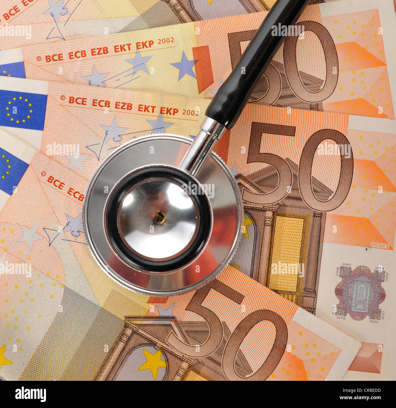 Stethoscope on euro banknotes, symbolic image of a sick euro currency or the increasing cost of health care Stock Photo