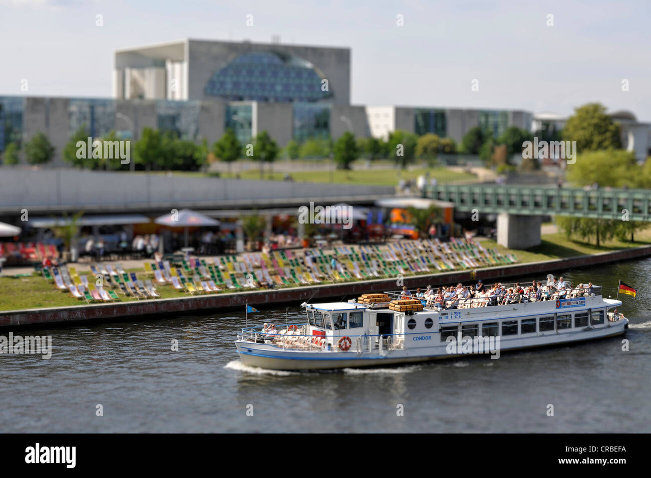 Excursion boat in front of the beach bar in the Spreebogen Park and the German Chancellery, miniature faking, smallgantics Stock Photo