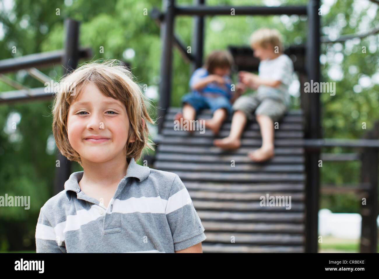 Smiling boy standing in playground Stock Photo - Alamy
