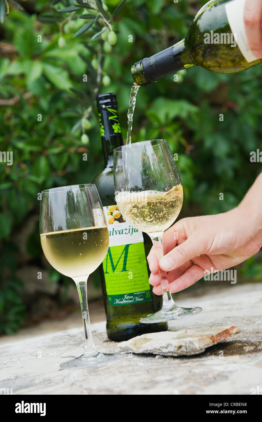 Pouring wine, bottle of white wine and wine glasses, Bol, Brac Island, Dalmatia, Croatia, Europe Stock Photo