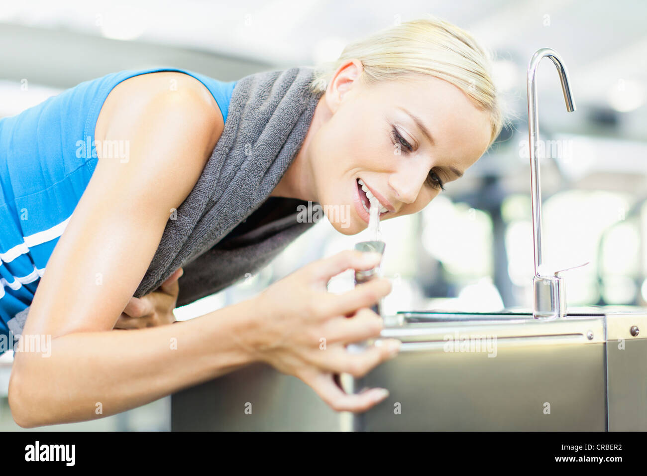 Woman drinking from water fountain Stock Photo