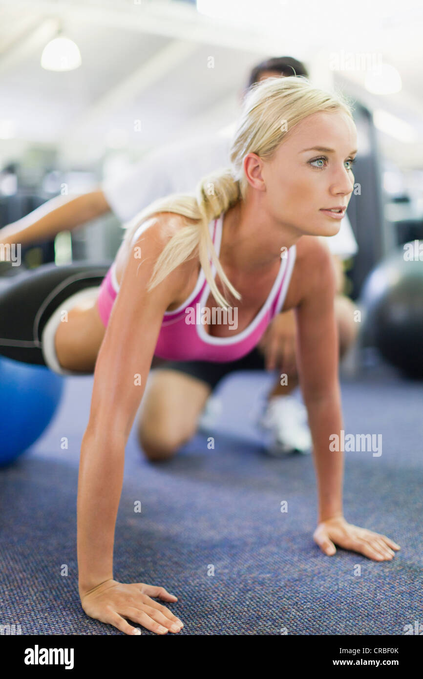 Woman working with trainer in gym Stock Photo
