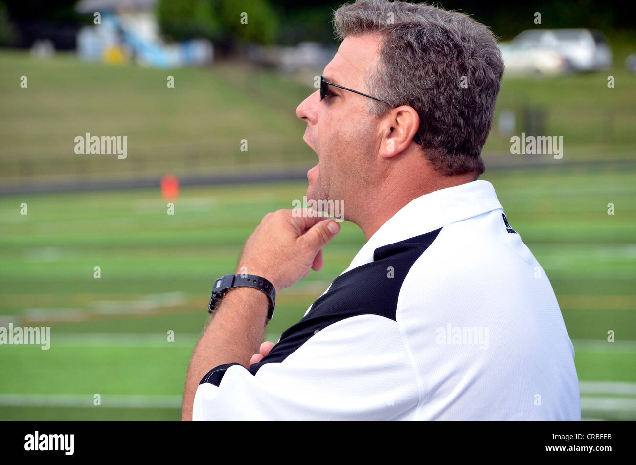 Coach shouts instruction from the sideline at a high school football game in Maryland Stock Photo