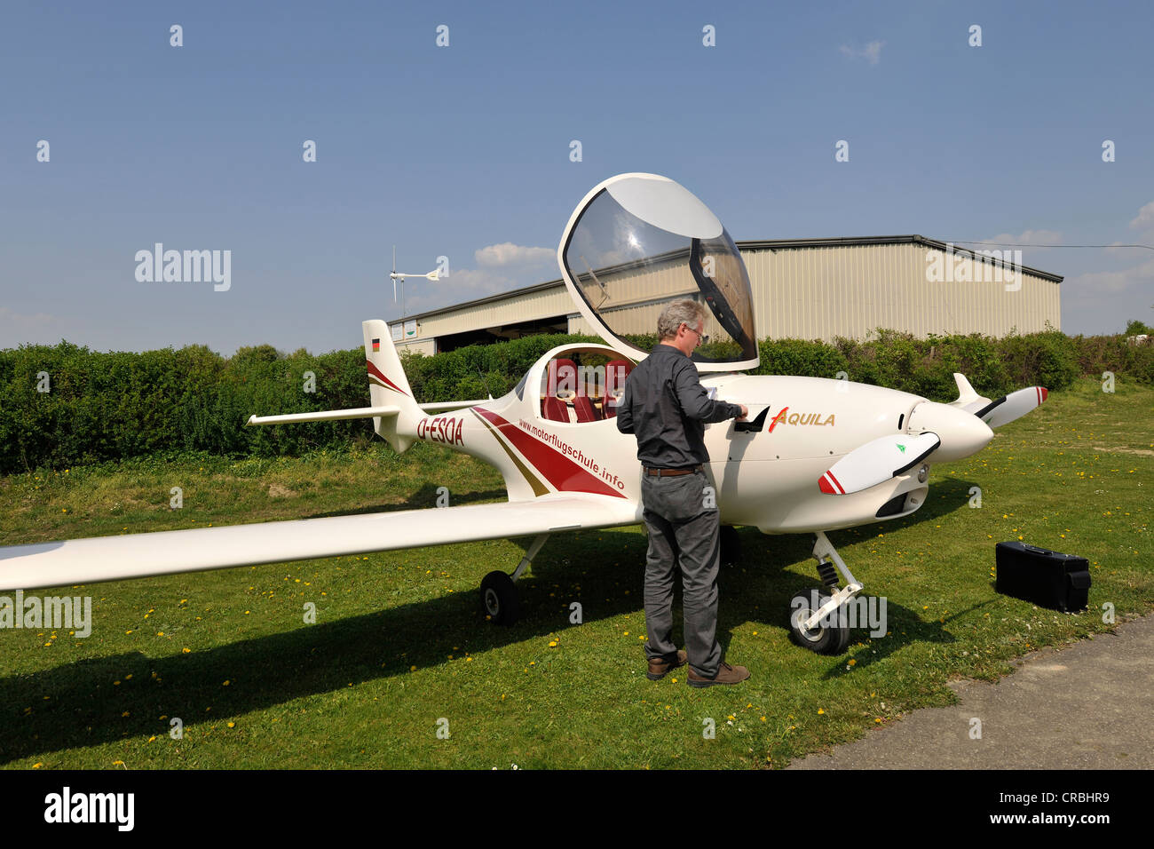 Pilot inspecting the cowling lid for measuring engine oil, light aircraft D-ESOA Aquila A210 AT01, Airport Hahnweide Stock Photo