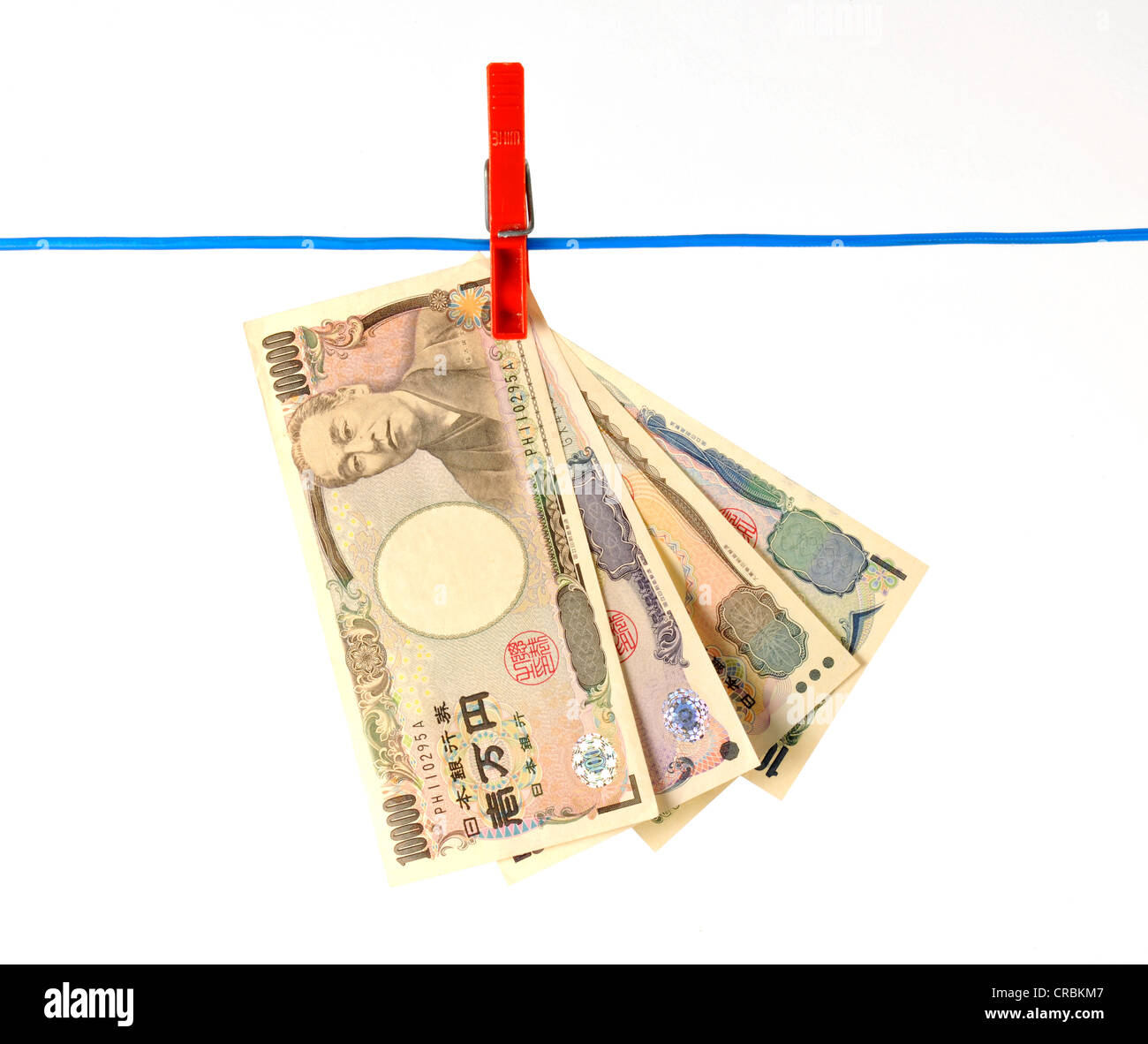 Fan of Japanese yen banknotes hanging on a clothesline, symbolic image