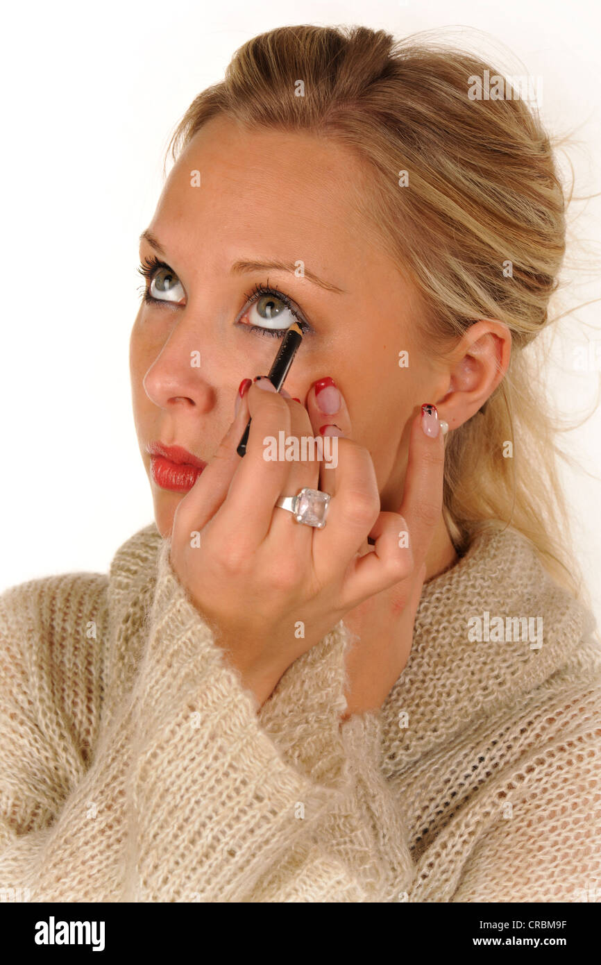 Young woman applying make-up, eyeliner Stock Photo