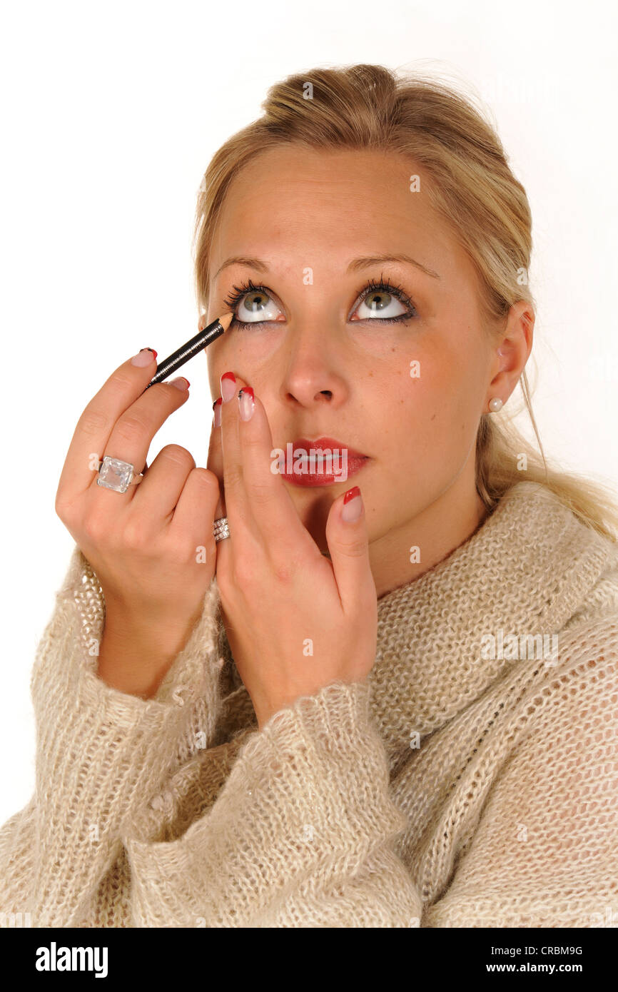 Young woman applying make-up, eyeliner Stock Photo