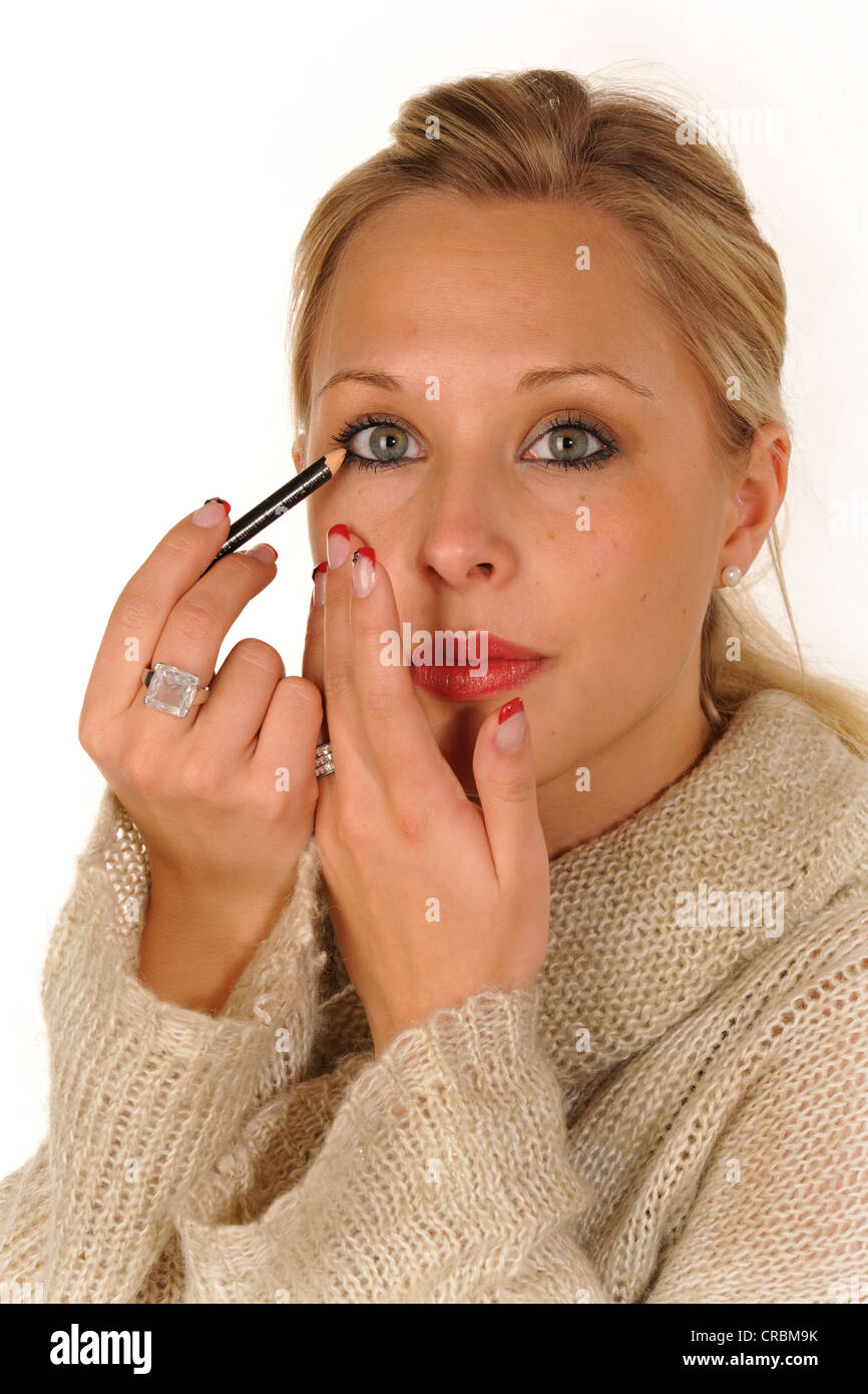 Young woman applying make-up, eyeliner Stock Photo