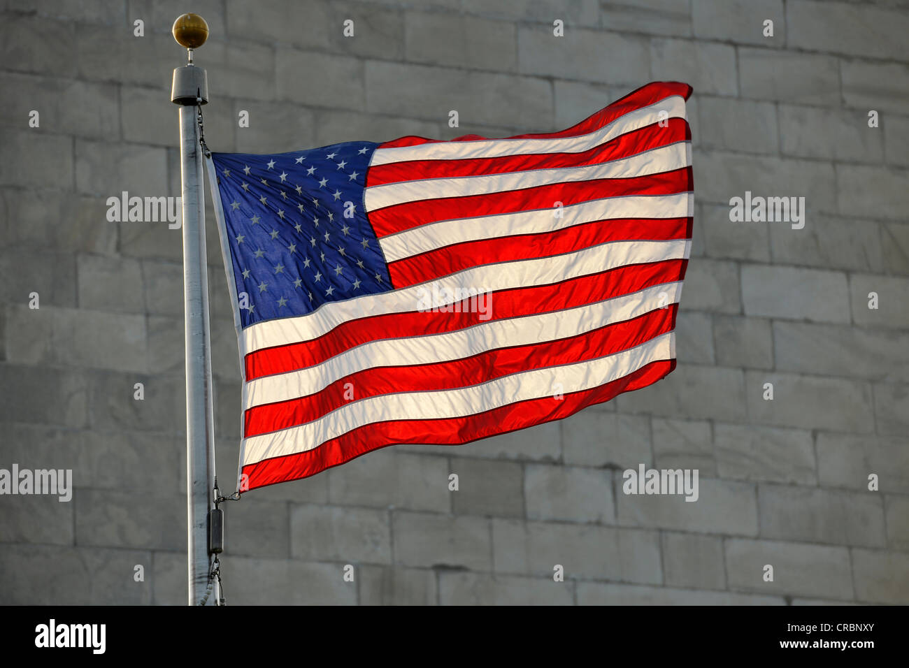 U.S. flag in front of the Washington National Monument, obelisk, Washington DC, District of Columbia, United States of America Stock Photo