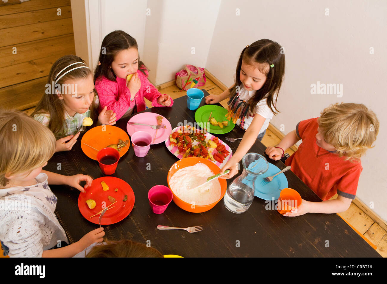 Children dipping vegetables in sauce Stock Photo