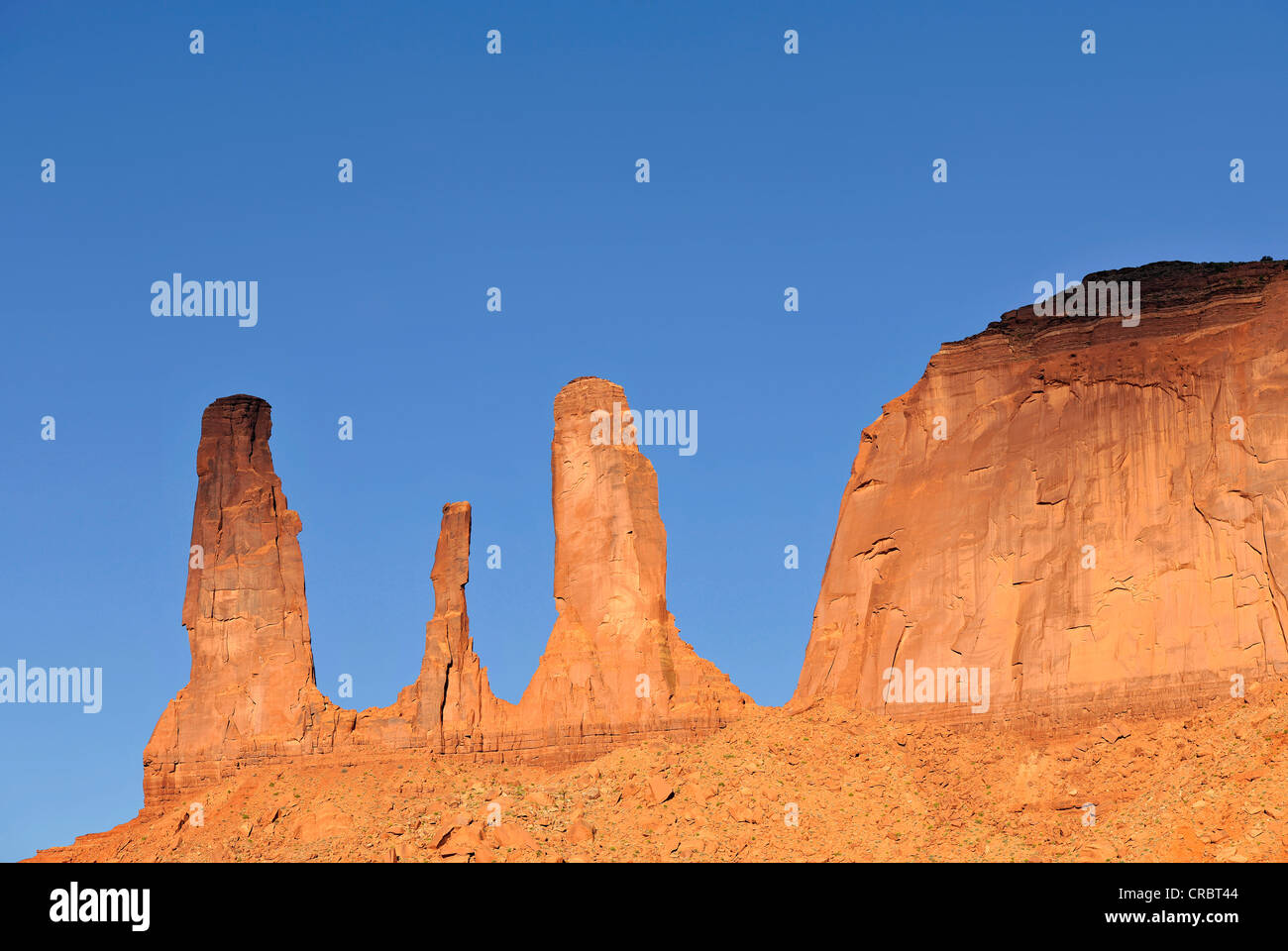 Three Sisters Pinnacles and Mitchell Mesa, rock formation in Monument Valley, Navajo Tribal Park, Navajo Nation Reservation Stock Photo