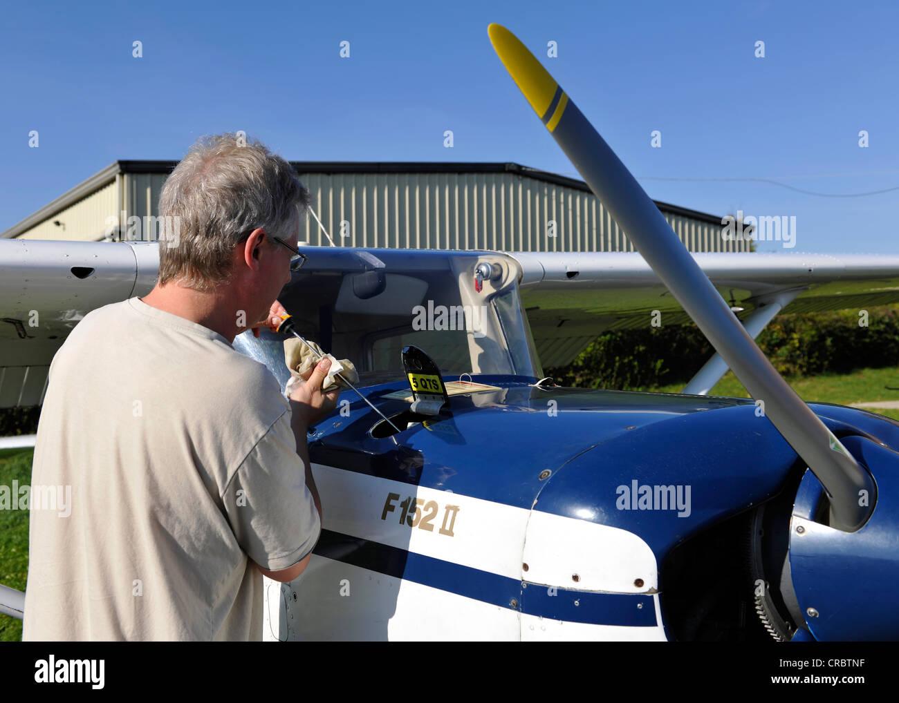 Pilot checking the engine oil of a Cessna 152 before a flight, Airport Hahnweide, Kirchheim unter Teck, Baden-Wuerttemberg Stock Photo