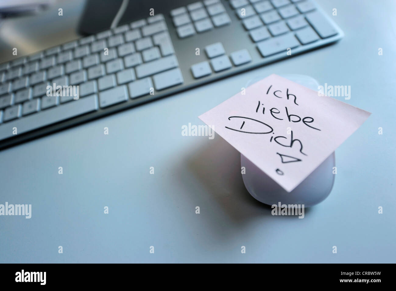 Sticky note with the words "Ich liebe Dich", German for "I love you", next to computer keyboard, symbolic image for love at the Stock Photo