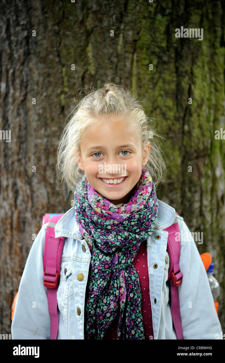 Girl, 9 years, with school backpack on the first day of school after