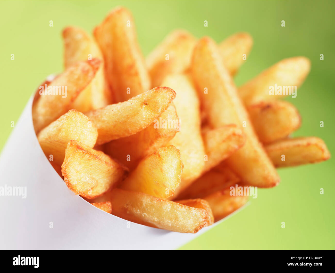 cone of chips fries against a green background Stock Photo Alamy