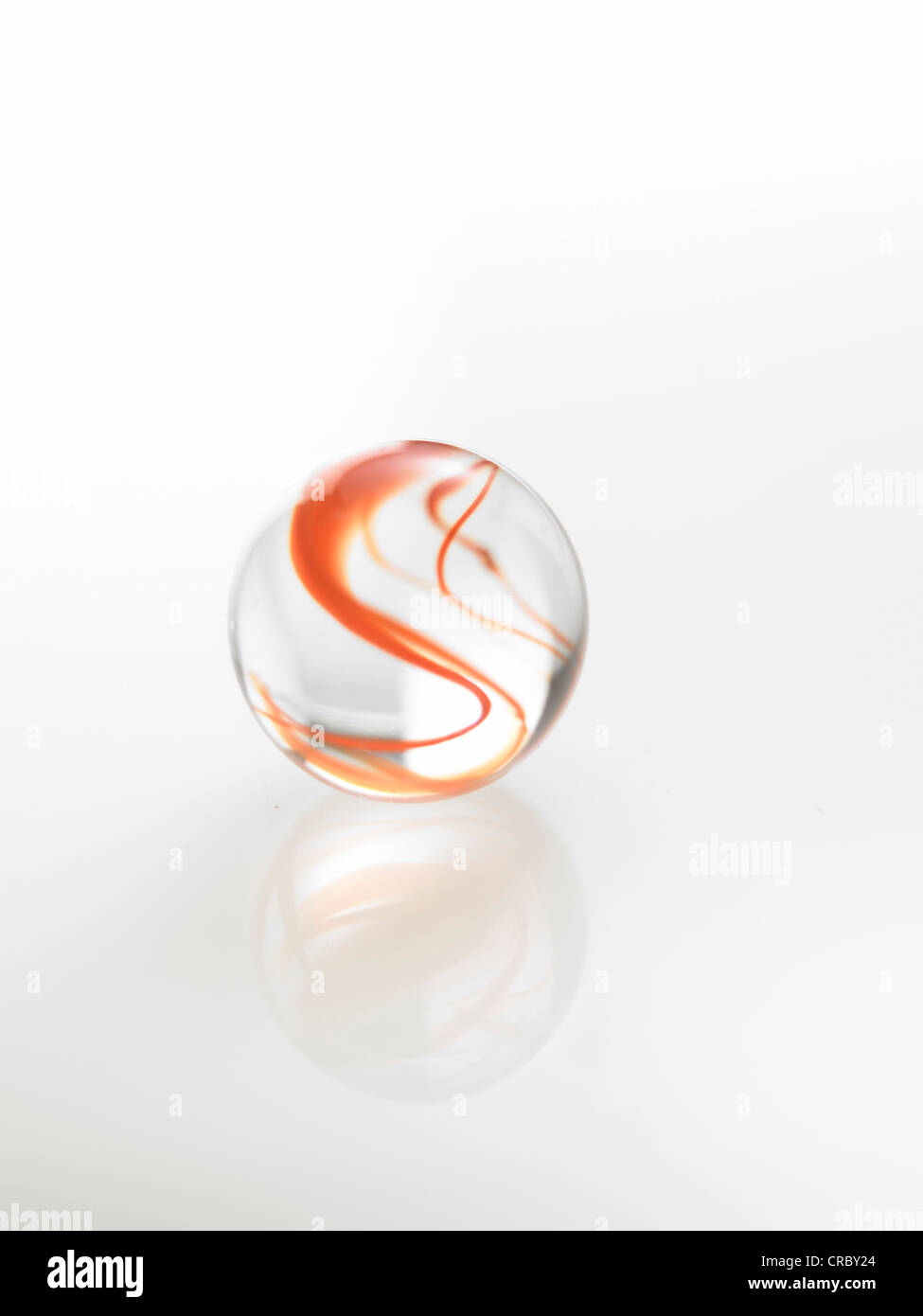 red colored glass marble on a reflective white background Stock Photo Alamy