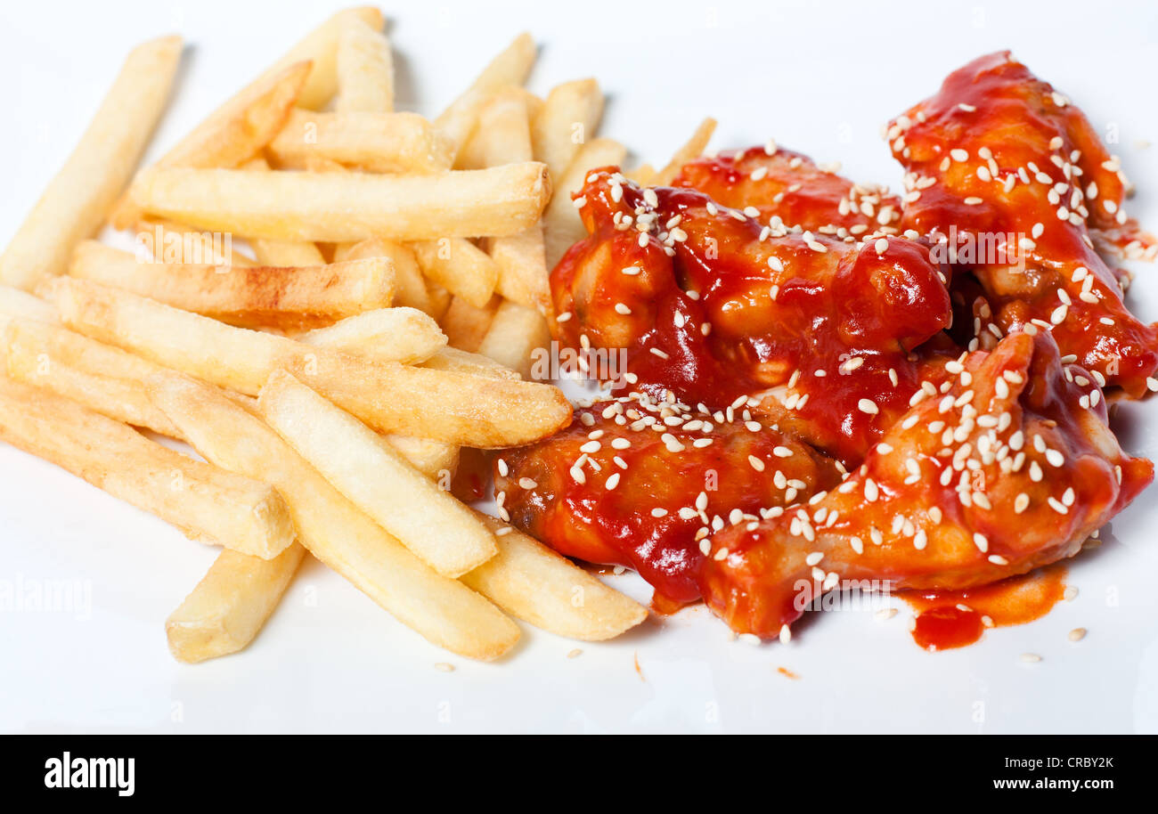 Chicken legs and fries in tomato sauce Stock Photo