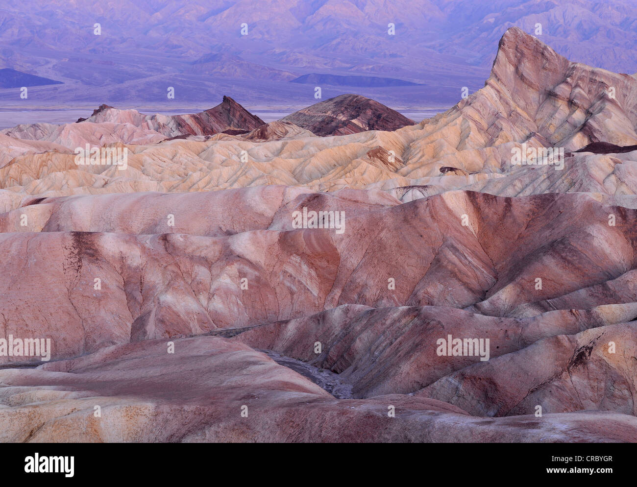 View from Zabriskie Point to Manly Beacon with its eroded rocks coloured by minerals, Panamint Range at back, dawn Stock Photo