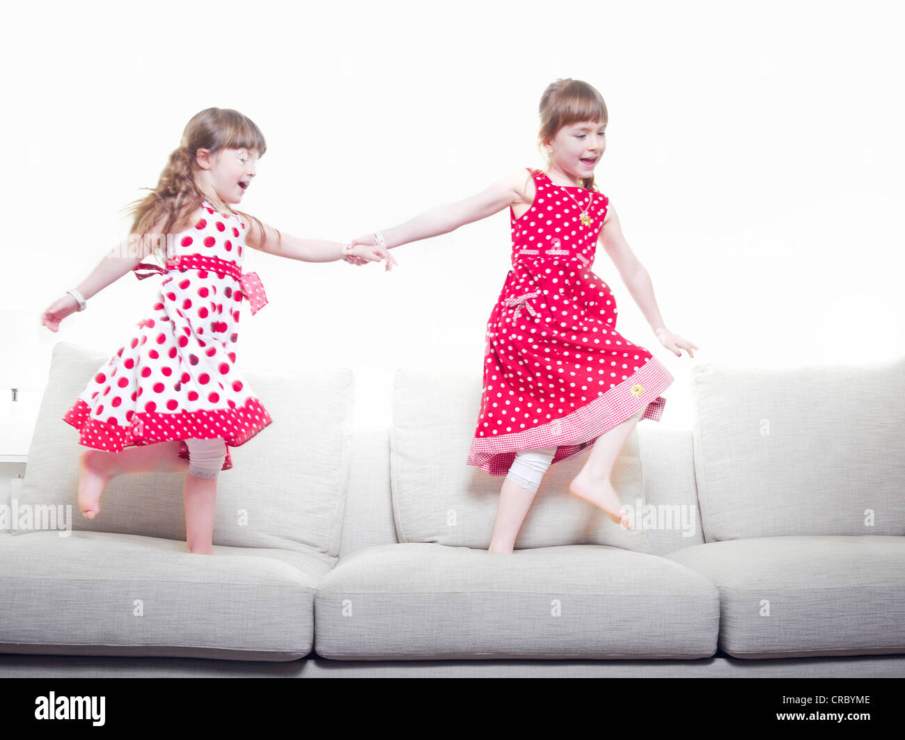 Girls playing together on sofa Stock Photo