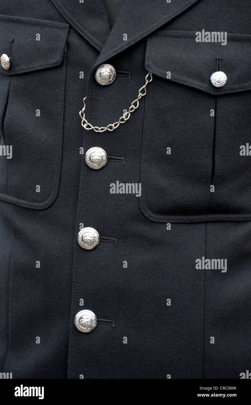 Close up of front of traditional London Metropolitan police uniform with shiny silver buttons and whistle chain Stock Photo
