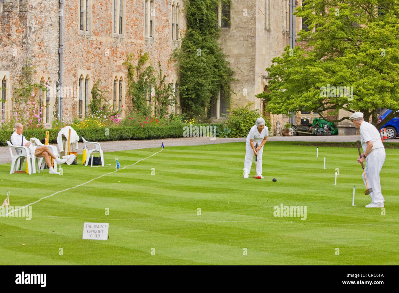 Members of the croquet club enjoy a game in the grounds of the Bishop’s Palace in the cathedral grounds at Wells in Somerset UK Stock Photo