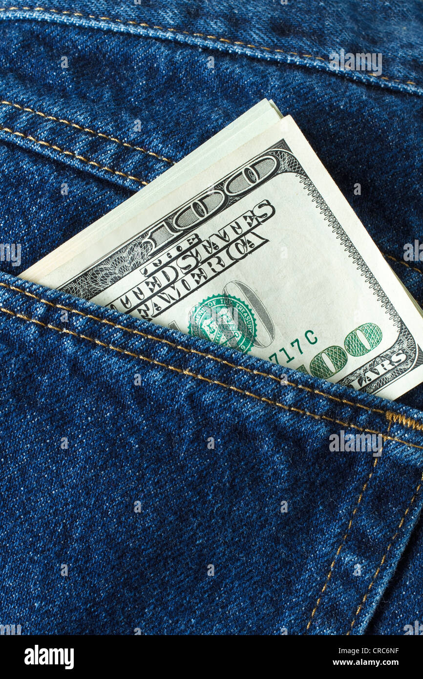 Close up photo of blue jeans showing hundred dollar bills sticking out of the back pocket Stock Photo