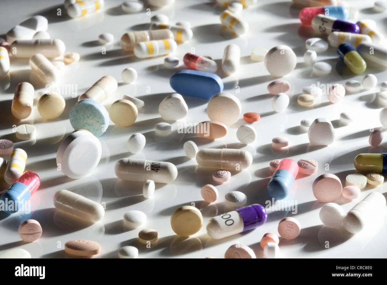 Pills scattered on reflective surface Stock Photo